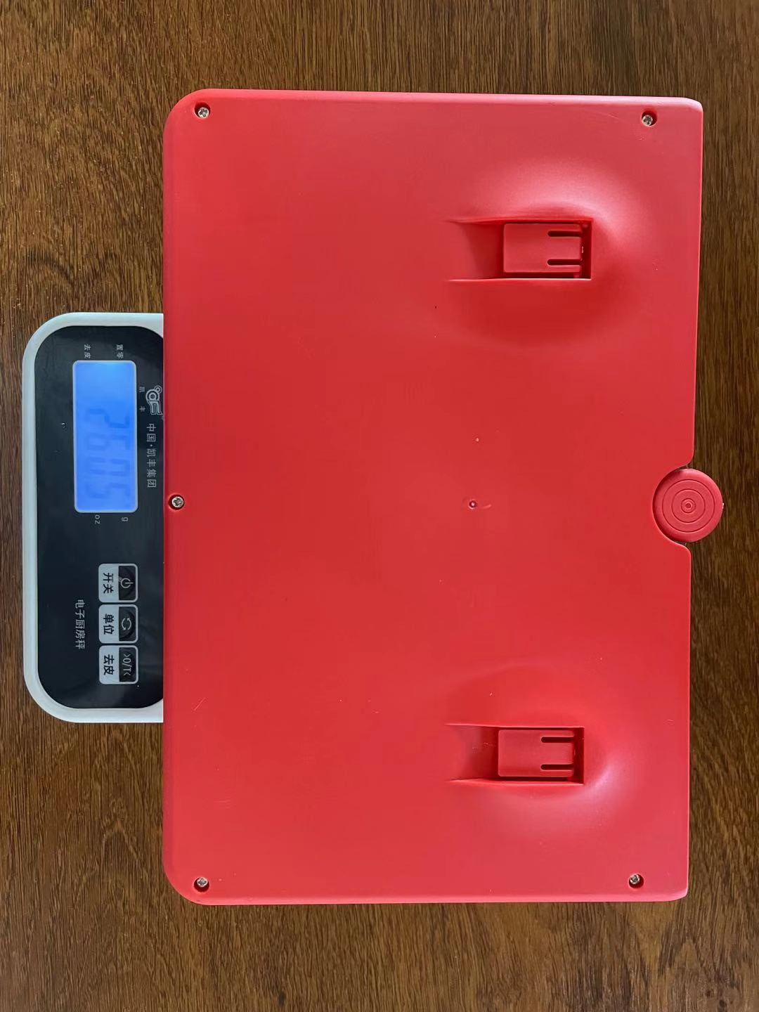 Red Multifunctional Mobile Phone Amplifier HD Screen 12-inch Screen Magnifier on a digital scale with a wooden surface background